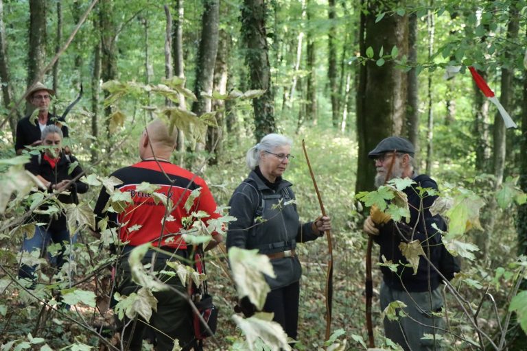 Gruppe von Bogenschützen mit Bögen steht im Wald zusammen