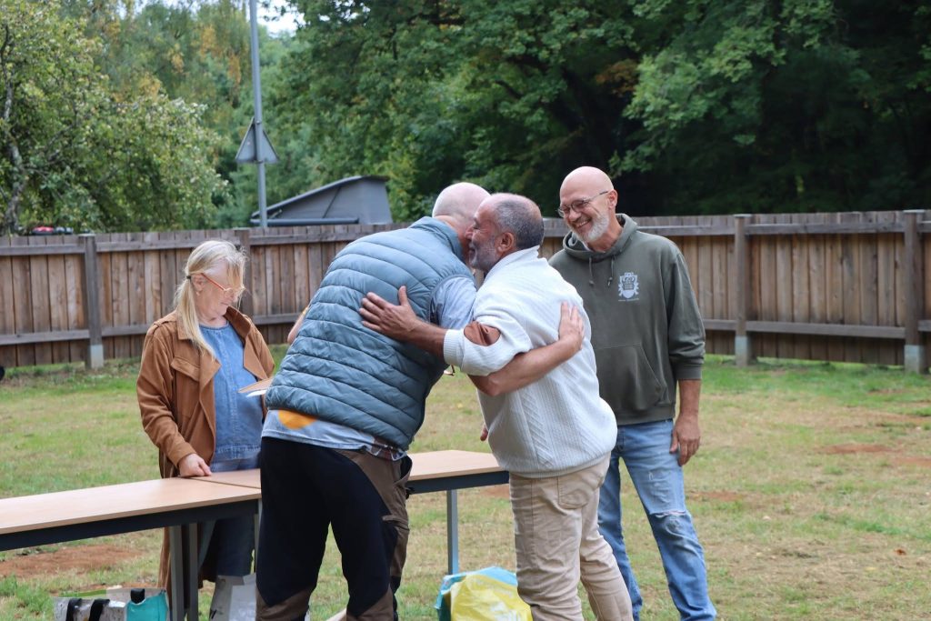 Zwei Männer umarmen sich herzlich bei der Siegerehrung auf der Wiese