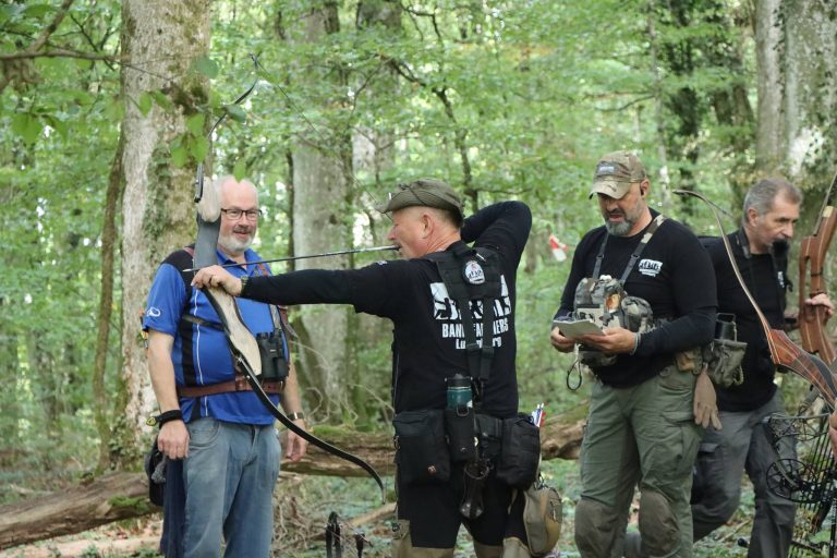 Bogenschützen besprechen an einer Station im Wald den nächsten Schuss