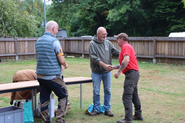 Zwei Männer geben sich bei der Siegerehrung die Hand