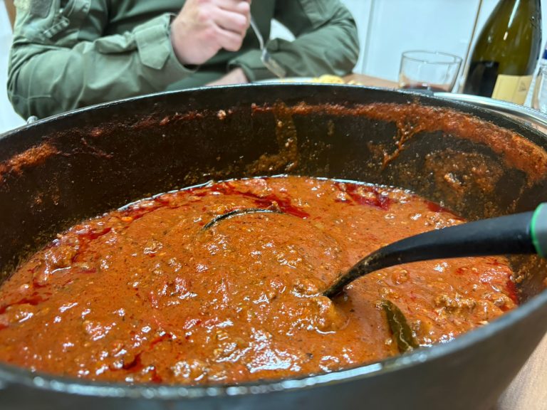 Großer Topf mit Tomatensauce und Schöpfkelle auf dem Tisch