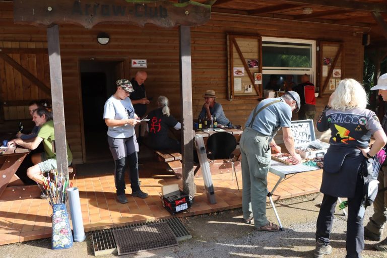 Besucher und Bogenschützen auf der überdachten Terrasse vor dem Vereinshaus
