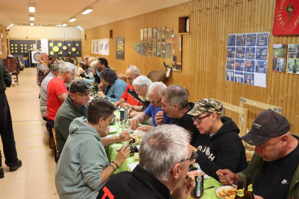 Voll besetzte Tischreihe im Vereinshaus mit Teilnehmern beim Essen