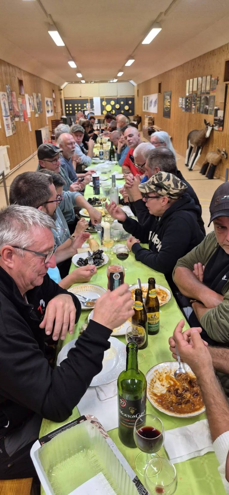 Lange Tafel im Vereinshaus mit zahlreichen Teilnehmern beim Essen