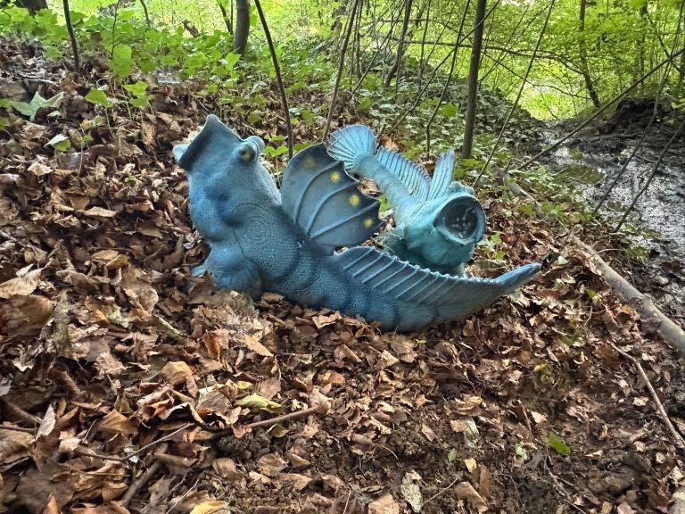Blaues 3D-Fischziel mit großen Flossen auf dem laubbedeckten Waldboden