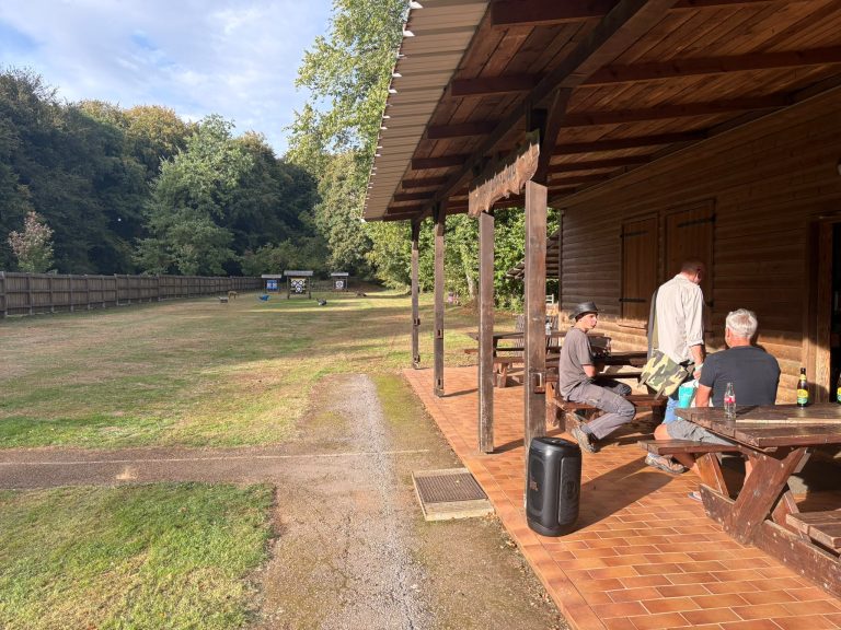 Überdachte Terrasse am Vereinshaus mit Sitzgruppen und Blick auf die Wiese