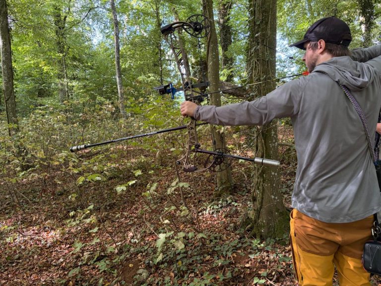 Bogenschütze mit gelber Hose zielt mit einem Compoundbogen vom Hang