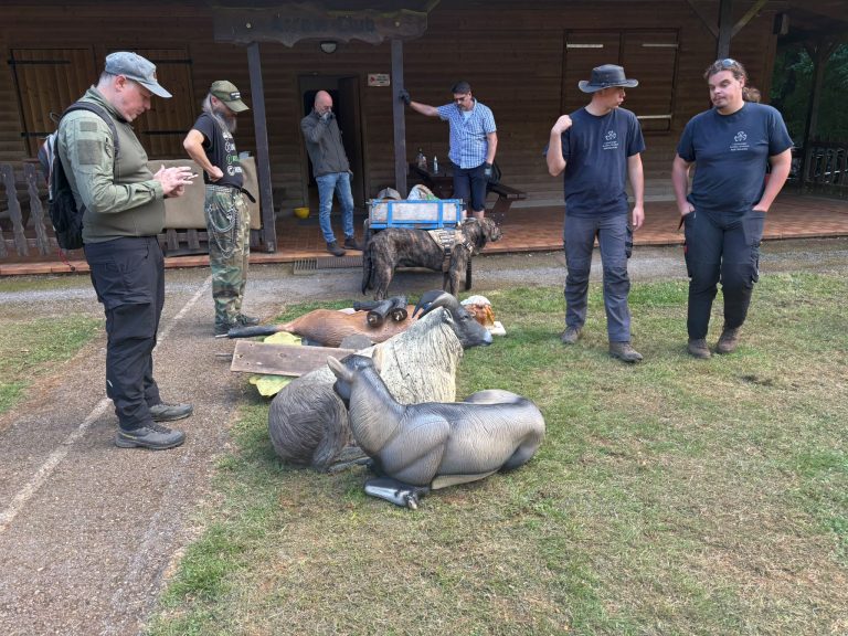 Männer stehen bei mehreren liegenden 3D-Tierzielen vor dem Vereinshaus