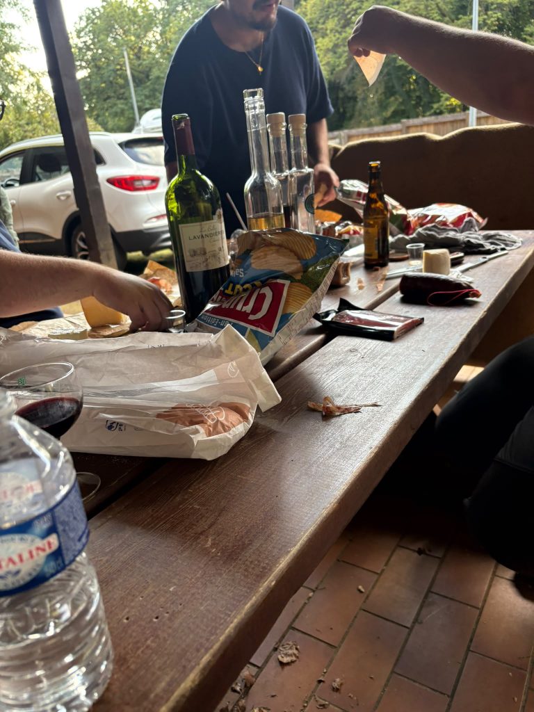 Tisch mit Weinflaschen und Snacks auf der Terrasse am Vereinshaus