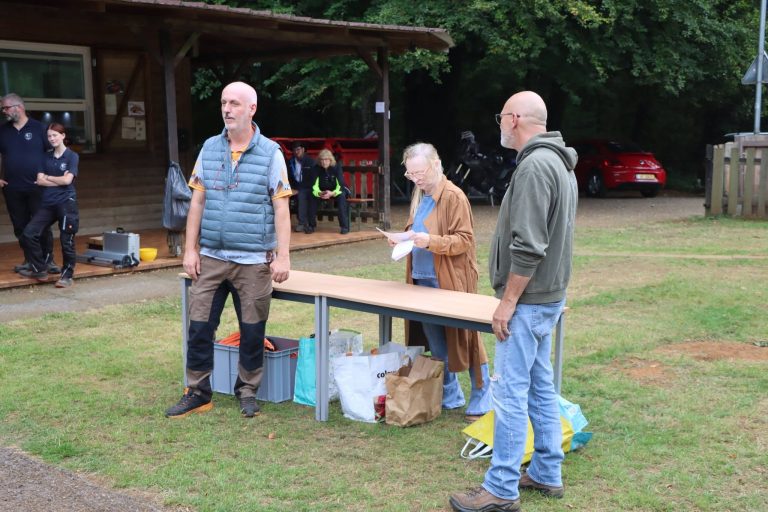 Drei Personen am Preistisch auf der Wiese vor dem Vereinshaus