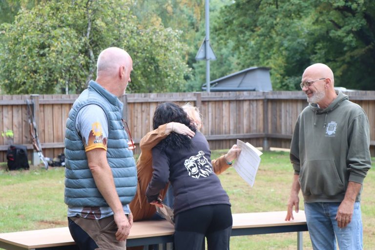 Mann in blauer Weste umarmt eine Teilnehmerin bei der Siegerehrung