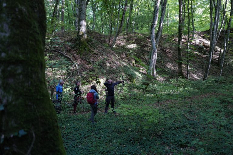 Gruppe von Bogenschützen auf einer Waldlichtung am Hang