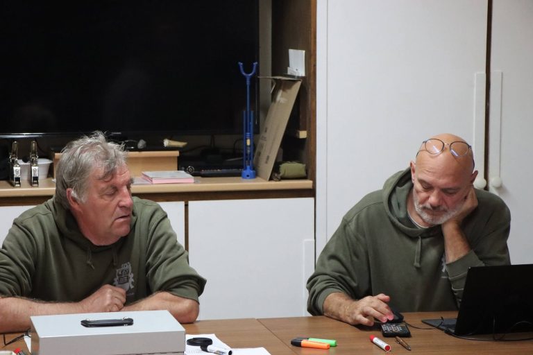 Zwei Männer sitzen mit Laptop am Tisch und werten die Ergebnisse aus