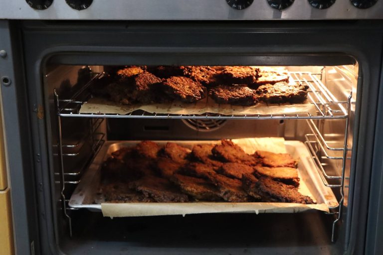 Zwei Backbleche mit Essen im Backofen der Vereinsküche